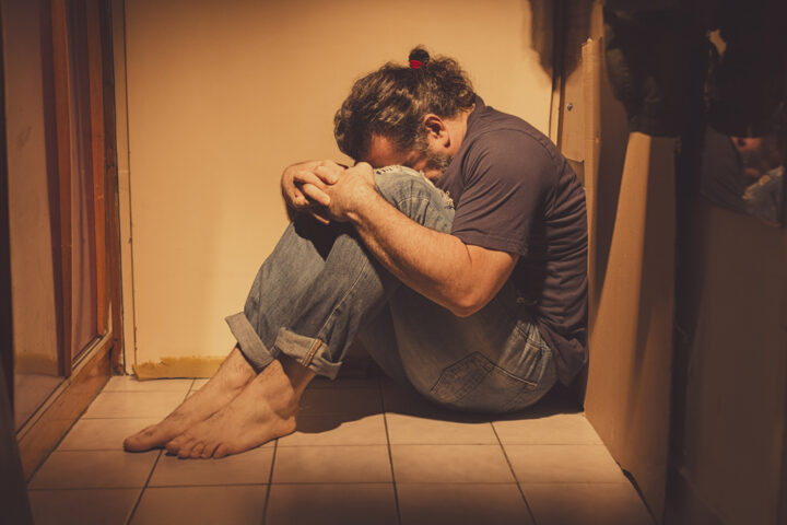 Depressed Man Sitting in Corner Depressed Man Sitting in Corner
